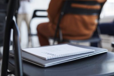 Close up background image of notebook on chair in audience at business conference or seminar, copy space